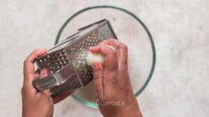 grating onion into bowl to make baked chicken meatballs