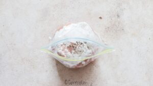 coating boneless chicken strips in corn starch in zip lock bag