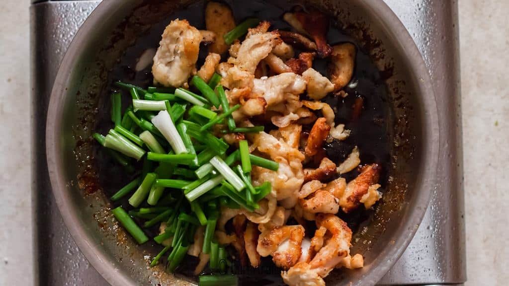 fried chicken and scallion added to pan to make Mongolian chicken