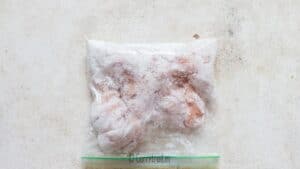 coating boneless chicken strips in corn starch in zip lock bag