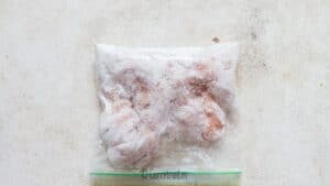 coating boneless chicken strips in corn starch in zip lock bag.