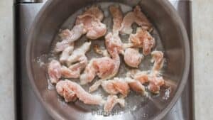 frying chicken coated in corn starch in oil