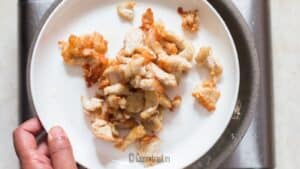 golden brown fried chicken was removed from the skillet onto a plate.