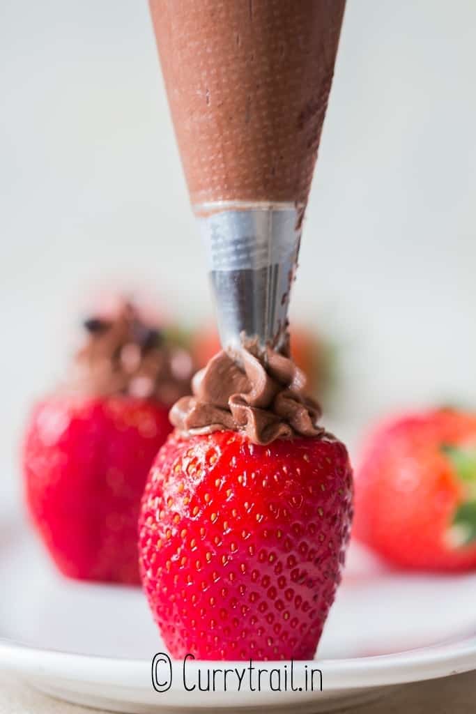 adding cheesecake stuffing into strawberries