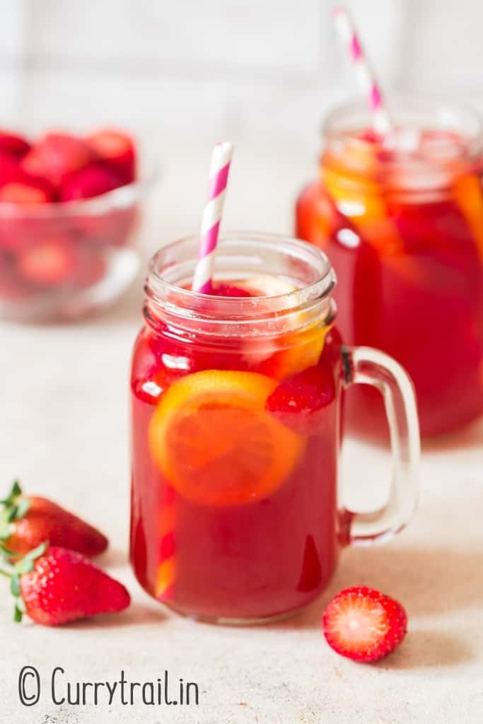 homemade southern sweet tea with strawberries in mason jugs