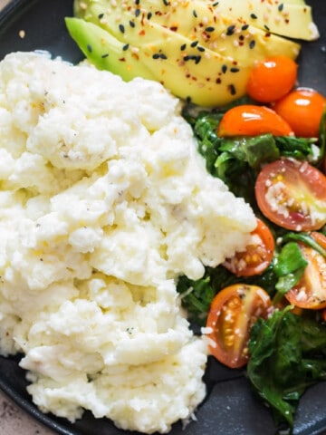 egg white scramble on plate with spinach, tomatoes and avocado