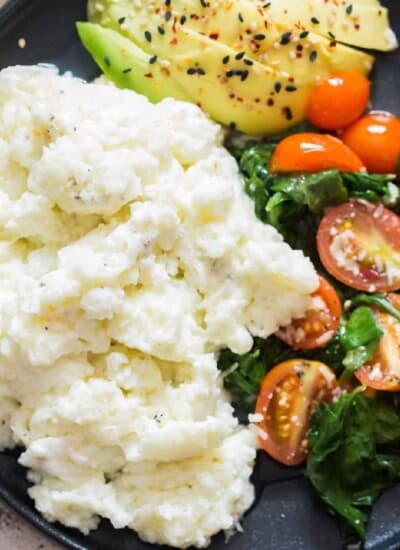 egg white scramble on plate with spinach, tomatoes and avocado