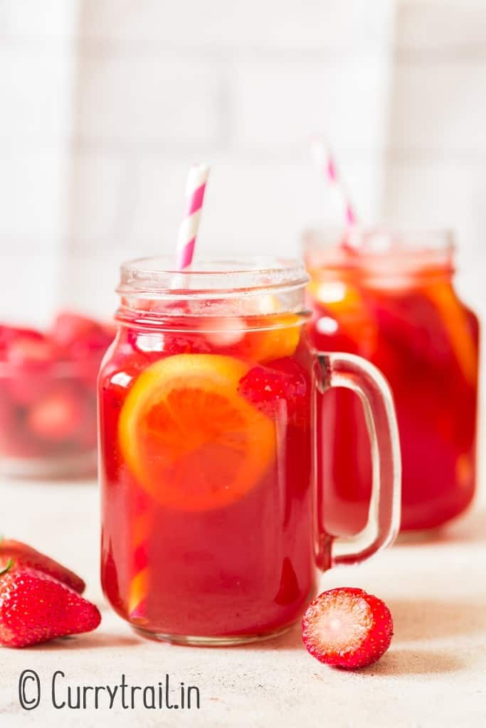 iced strawberry tea served in two mason jars.