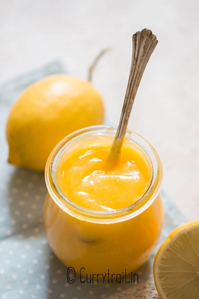 smooth homemade lemon curd in jar with spoon