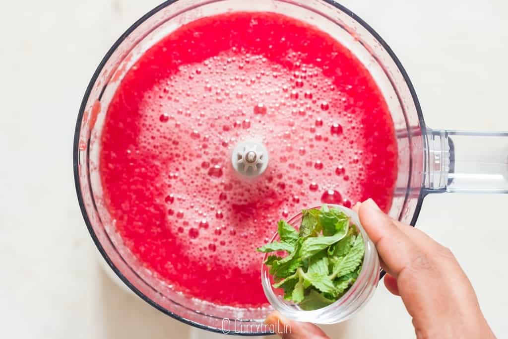 mint leaves is added to watermelon juice in a food processor.