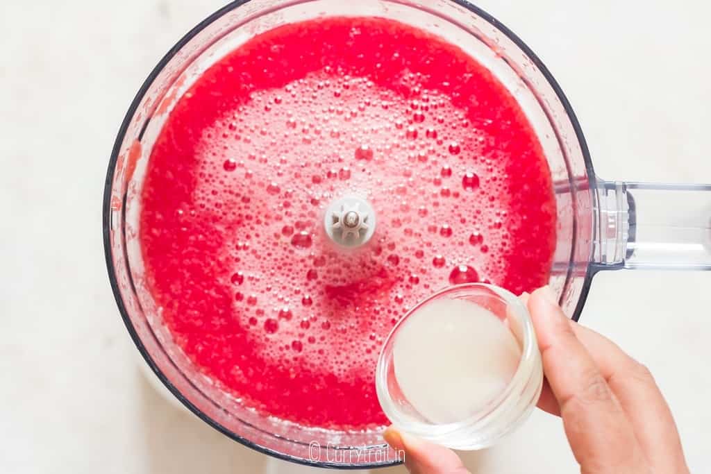 freshly squeezed lime juice is added to watermelon juice in a food processor.