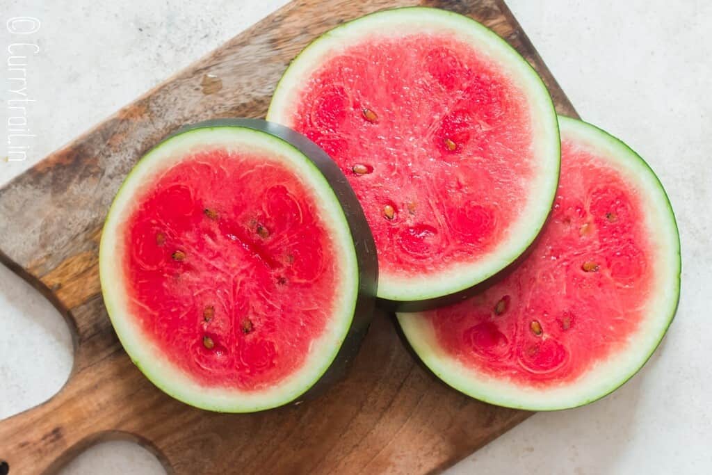 cut watermelon slices on a wooden board.