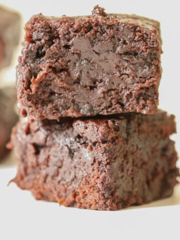 zucchini brownies stacked one on top of each other.