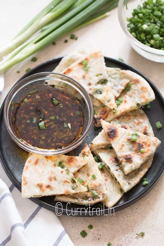 savory pancakes with scallion stuffing cut into triangles with dipping sauce