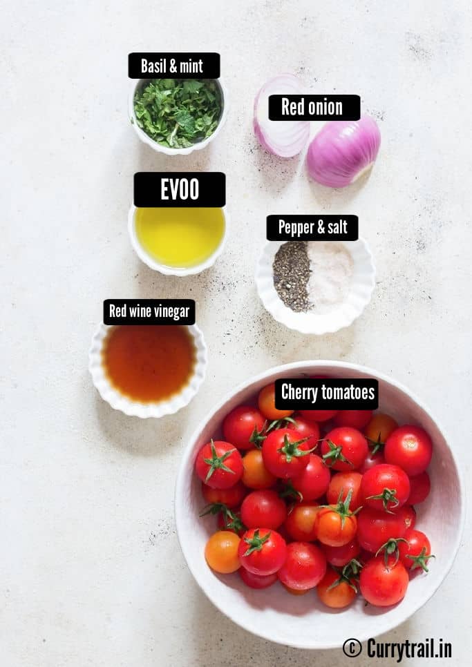 all the ingredients for cherry tomato salad were placed on a table.