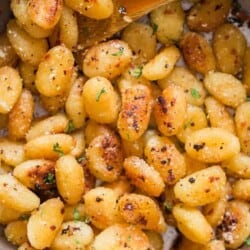 fried gnocchi in garlic butter sauce in skillet