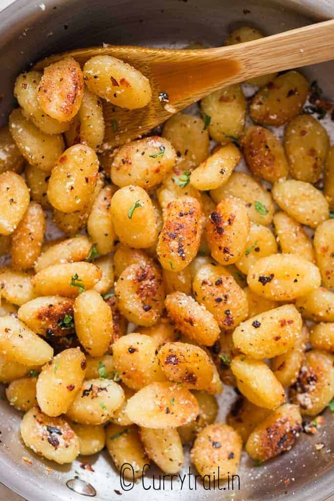 fried gnocchi in garlic butter sauce in skillet
