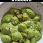 creamy gnocchi in pesto cream sauce in bowl with text