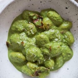 creamy gnocchi in pesto cream sauce in bowl