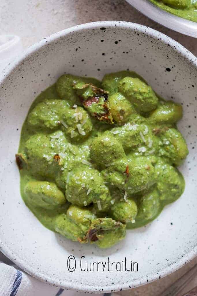 creamy gnocchi in pesto cream sauce in bowl