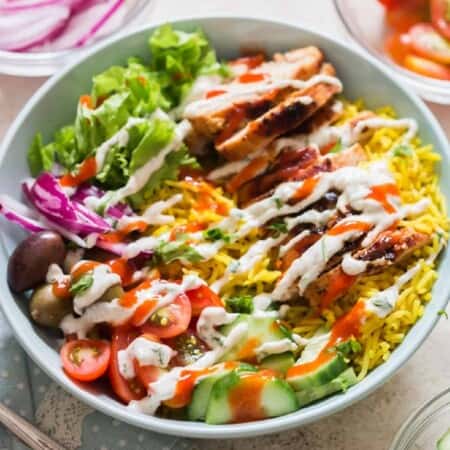 easy chicken shawarma bowl with hummus dressing and red chili sauce