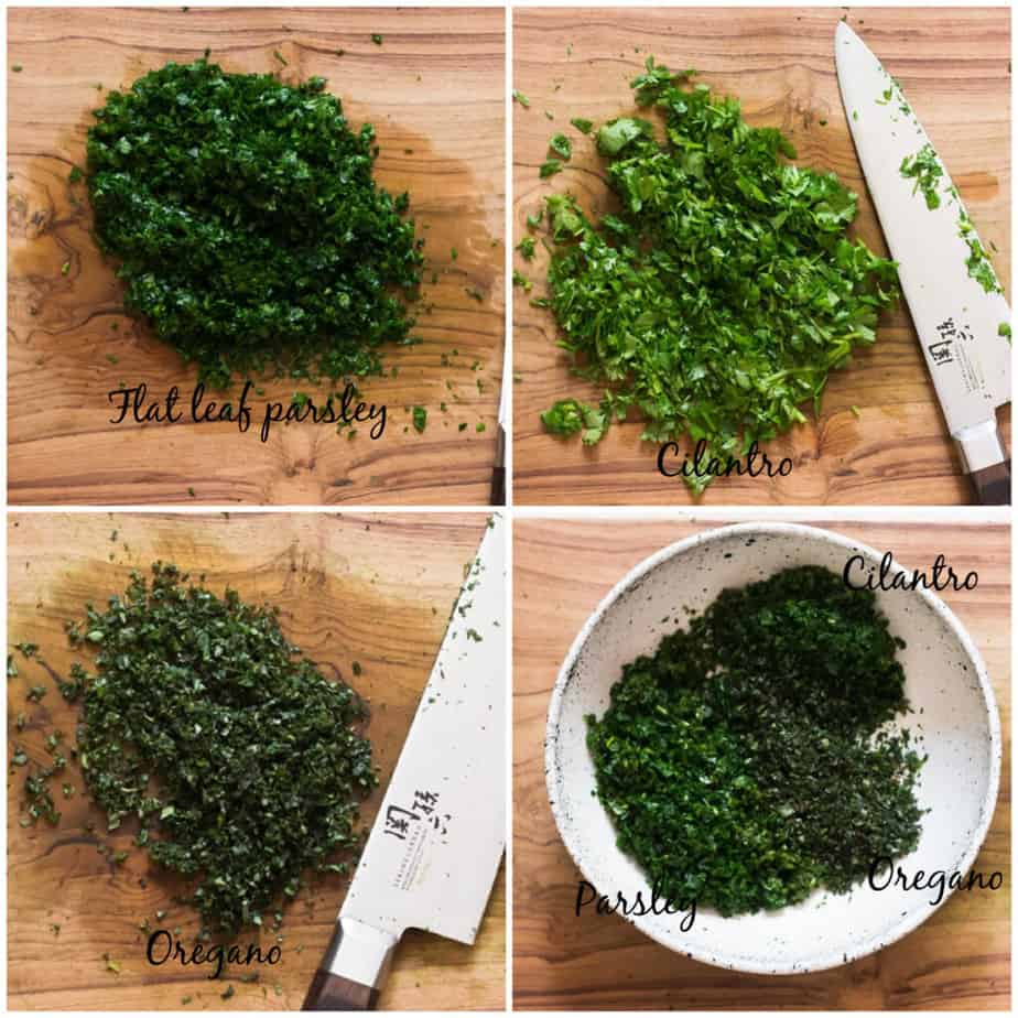 chopping herbs for chimichurri sauce on wooden board.
