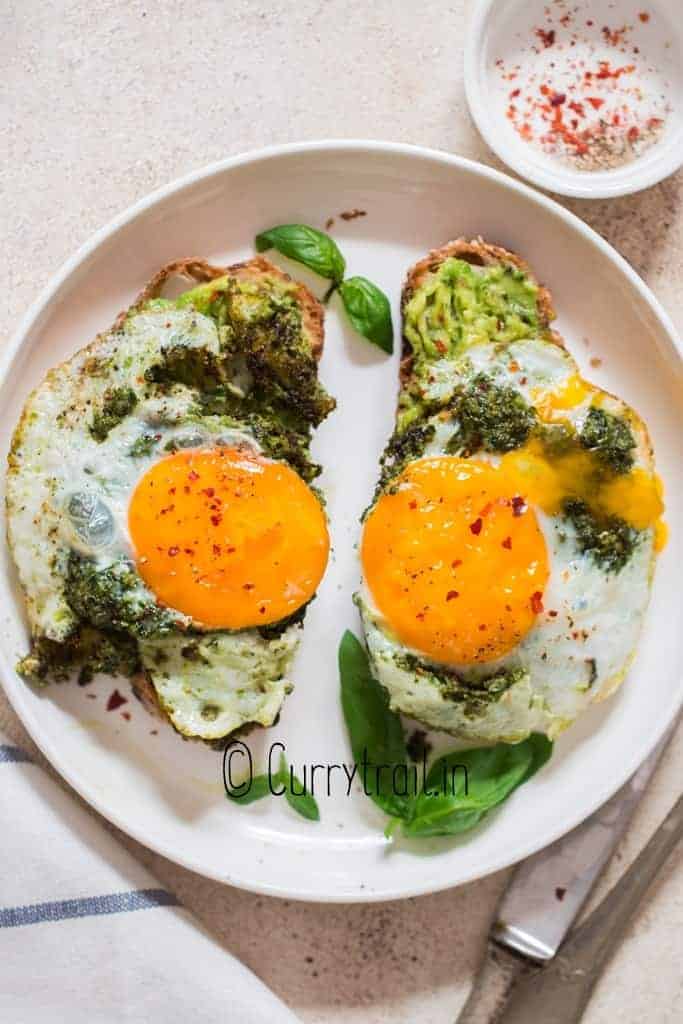 two avocado toast with pesto eggs on it