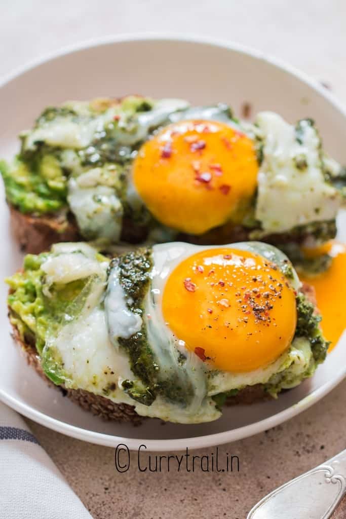 two avocado toast with pesto eggs on it