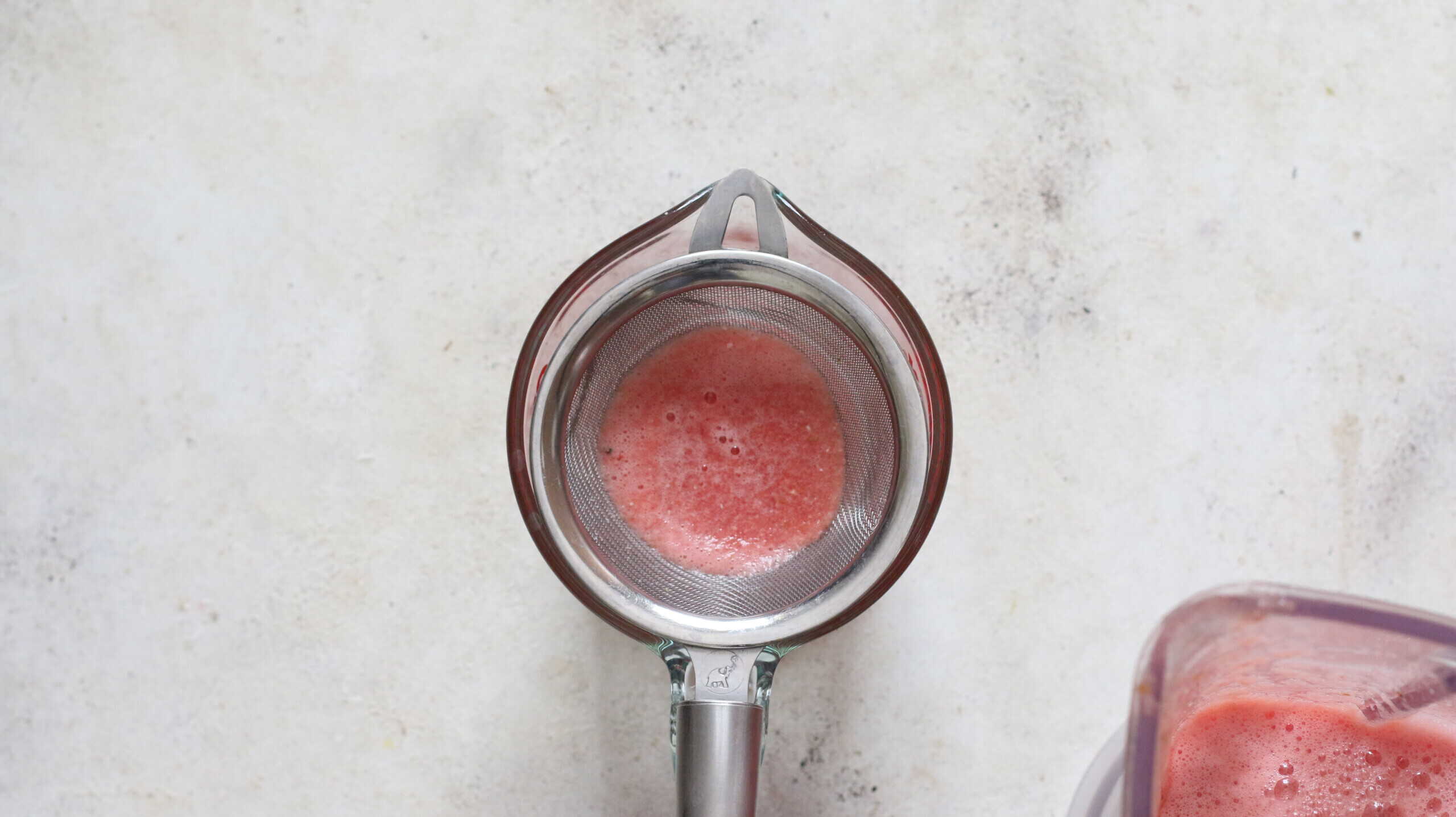 straining watermelon juice.