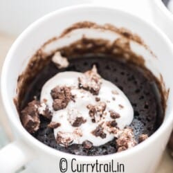 1 minute oreo mug cake with whipped cream and oreo crumbs on top