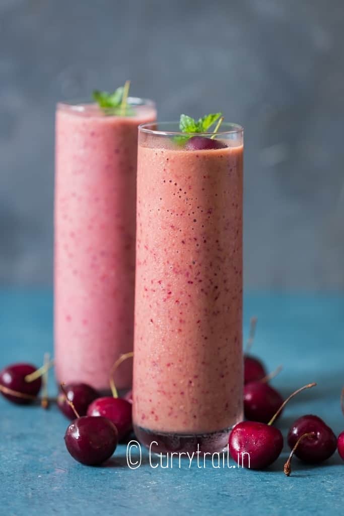 pretty pink smoothie made of frozen cherries served in 2 glasses