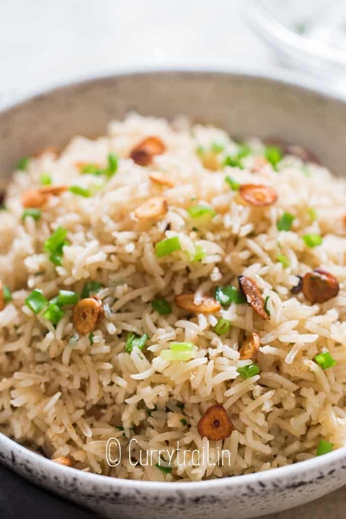 garlic fried rice with crispy garlic chips and scallions as garnish on top