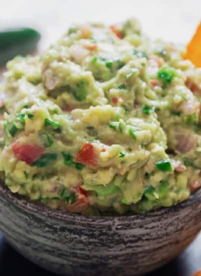 guacamole in a bowl with nacho chips.