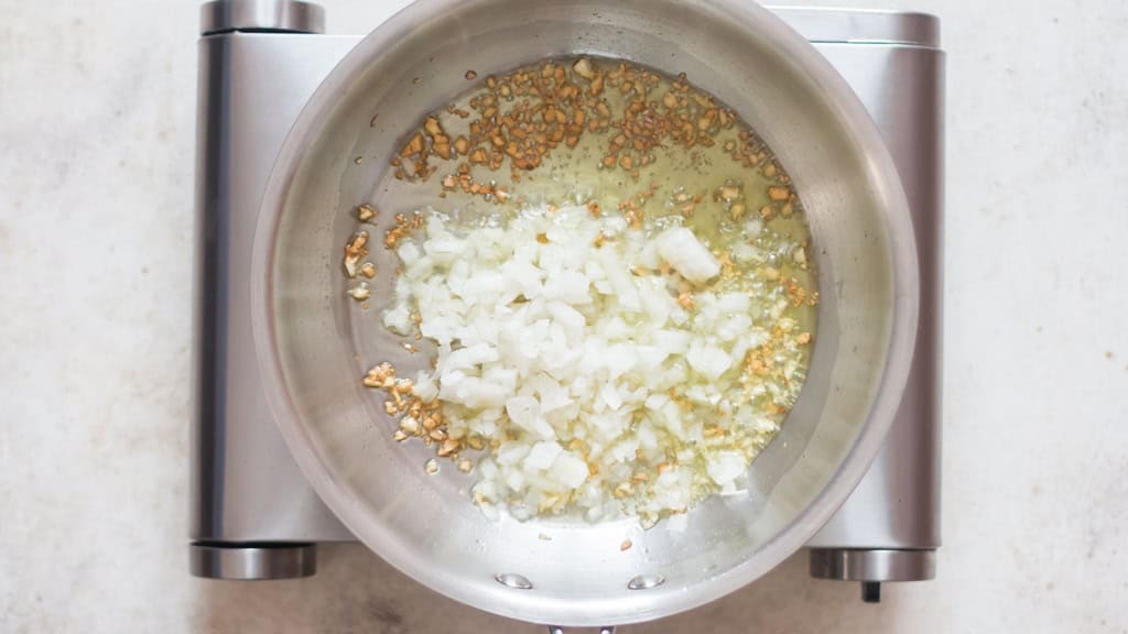 onion and garlic sautéed in olive oil in a skillet.
