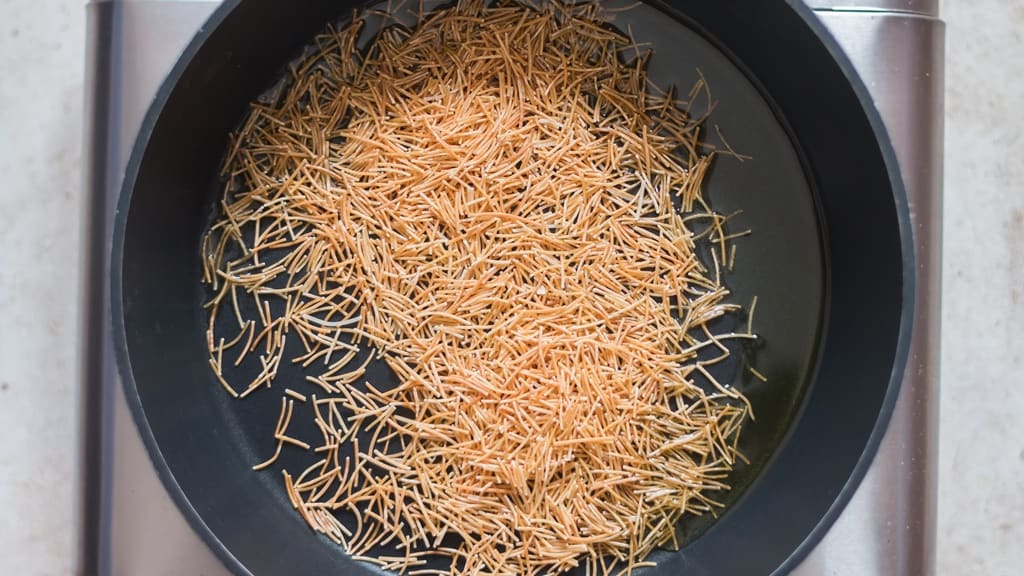 sautéing vermicelli in a skillet.