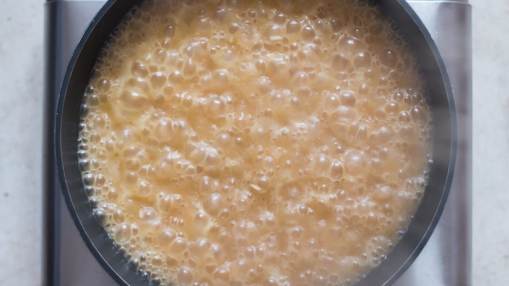 cooking rice and vermicelli in stock in a pot.