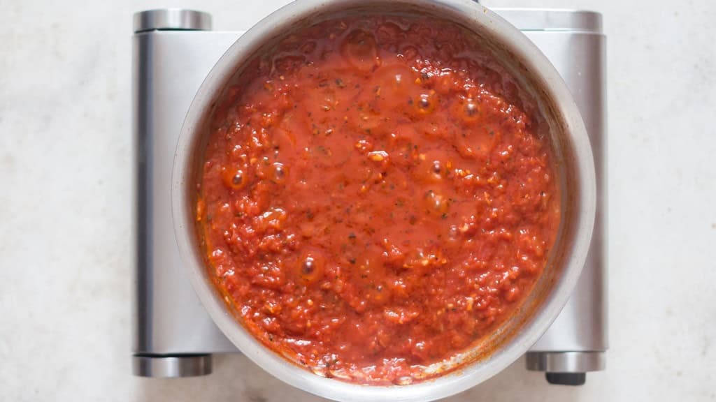 cooking marinara sauce in a skillet.
