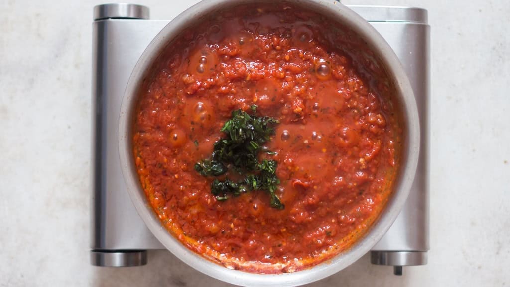 cooking marinara sauce in a skillet.