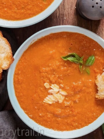 thick tomato soup with basil leaves in a bowl.