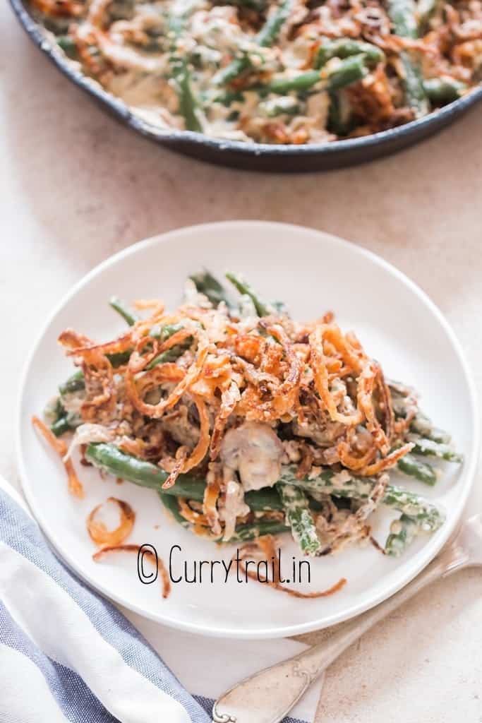 green beans cooked in creamy gravy served in plate with crispy onions on top