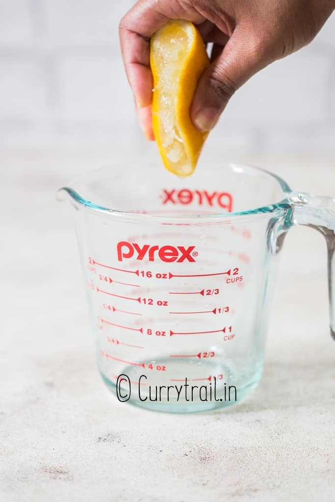 squeezing lemon juice into a jar