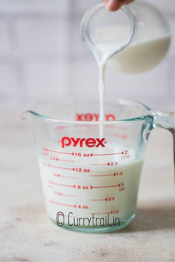 pouring milk into the jar to make homemade buttermilk