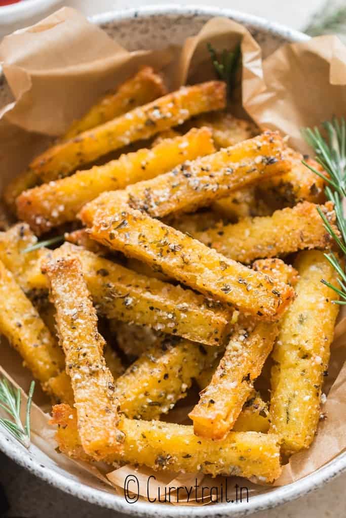 close up view of crispy baked polenta fries with ketchup