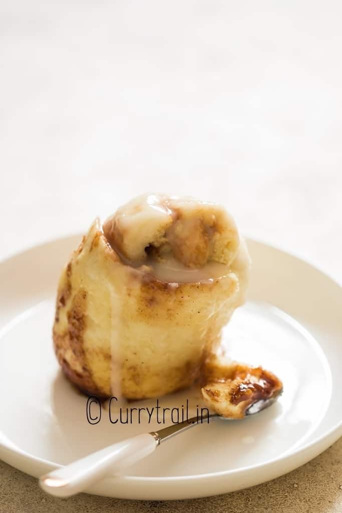 microwave cinnamon roll in a mug with glaze