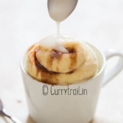 microwave cinnamon roll in a mug with glaze,