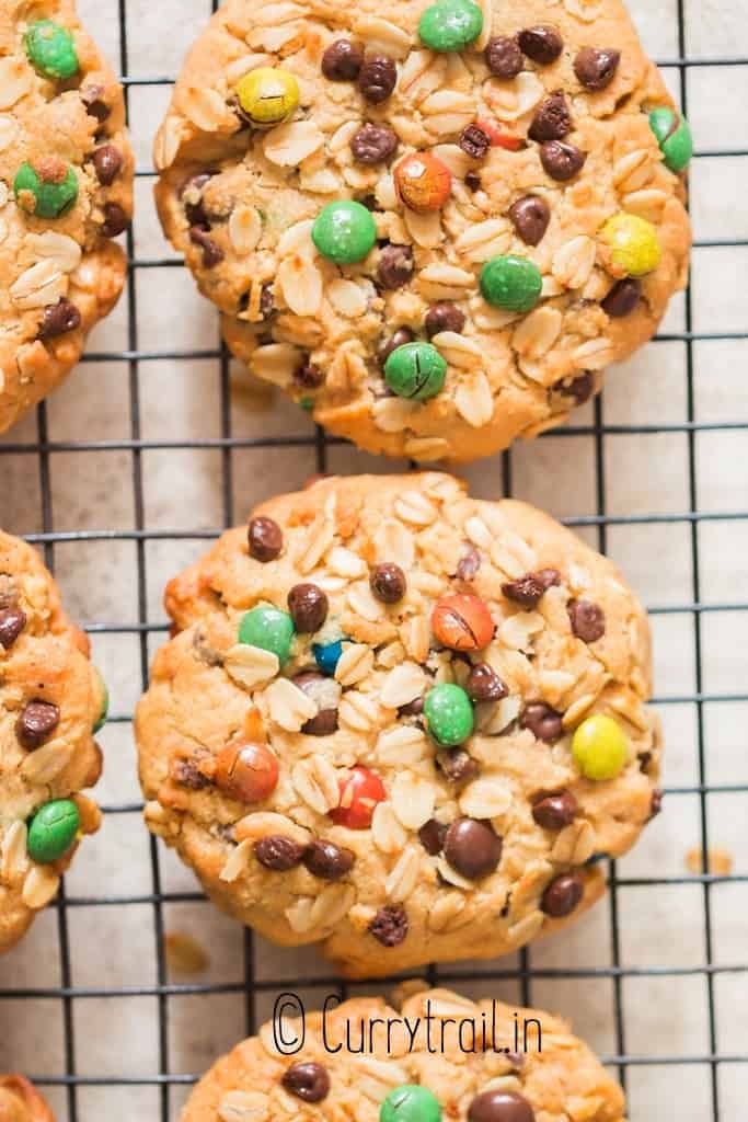 thick chewy monster cookies on wire rack