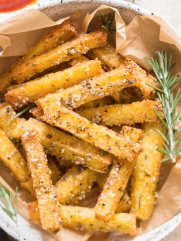 close up view of crispy baked polenta fries with ketchup