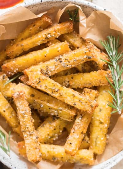 close up view of crispy baked polenta fries with ketchup