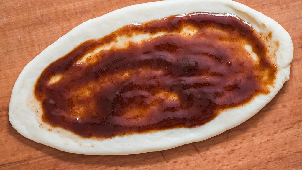 cinnamon butter filling spread on rolled dough.
