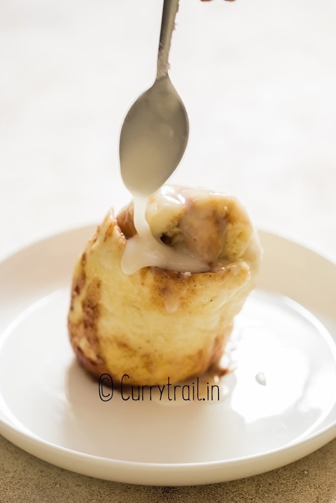 sugar glaze drizzled on cinnamon roll made in the microwave.